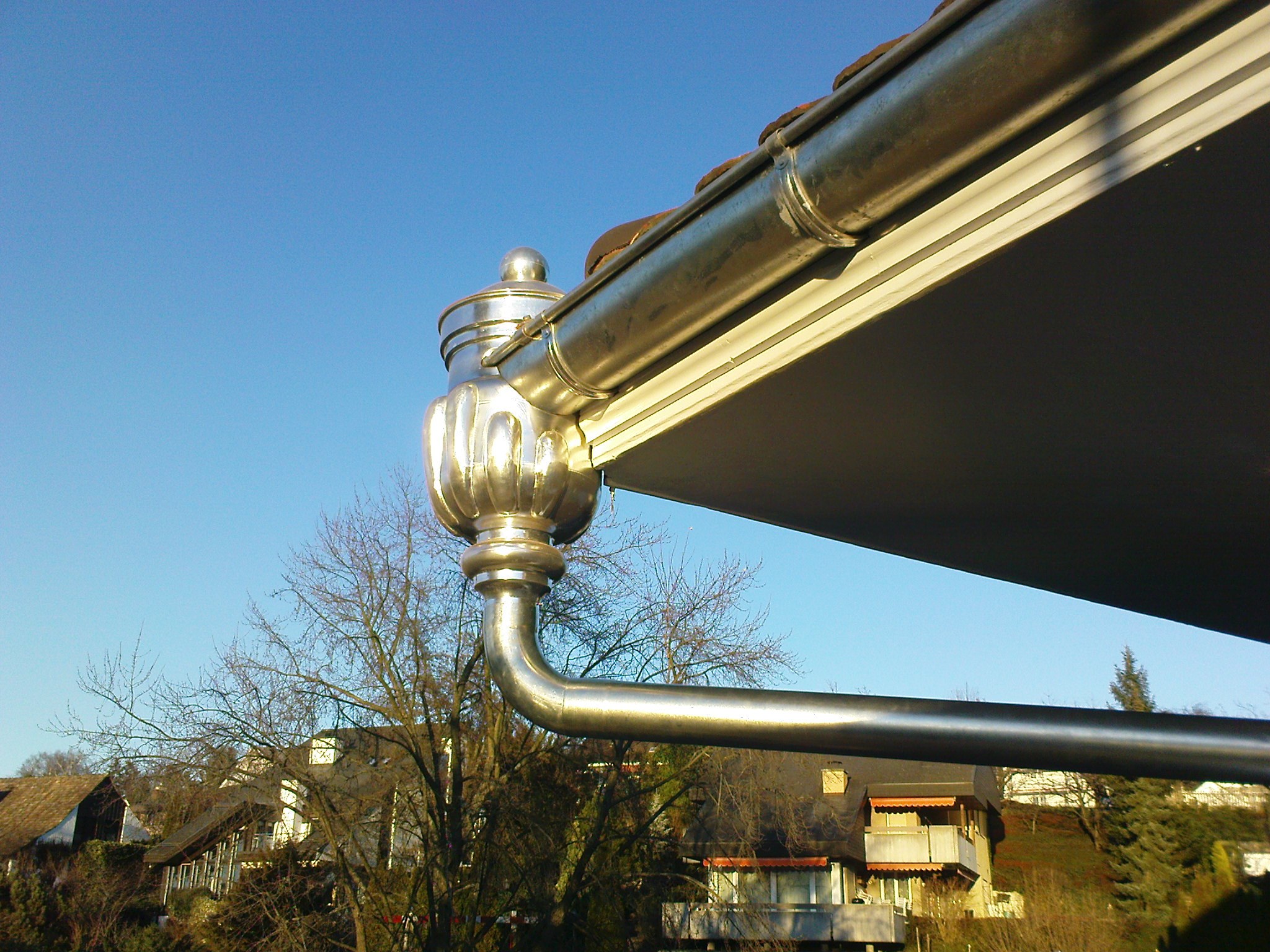 Goldfarbene Dachrinne mit Zierknauf an der Villa in Herrliberg